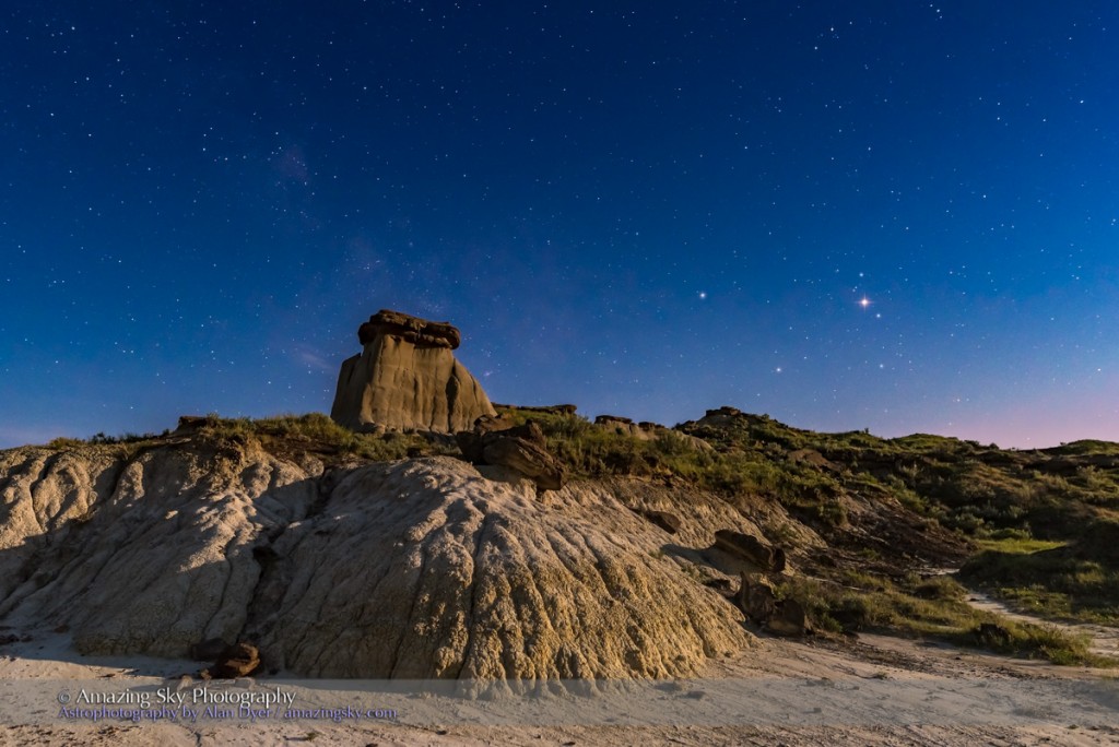 Mars (at right) shining brightly near opposition in the head of Scorpius over the badlands of Dinosaur Provincial Park, Alberta. Saturn is to the left of Mars, with Antares in Scorpius below the two planets, forming a triangle of “stars” in the moonlit sky. A waxing gibbous Moon off frame at right supplies the illumination. The Milky Way is barely visible at left in the moonlit sky. Dinosaur Provincial Park is a UNESCO World Heritage site, preserving the world’s richest collection of late Cretaceous fossils from the end of the age of dinosaurs. I shot this the night of May 16/17 from The Trail of the Fossil Hunters trail. This was with the Nikon D750 and Sigma 24mm lens. I shot this at the end of a 3-hour time-lapse sequence.