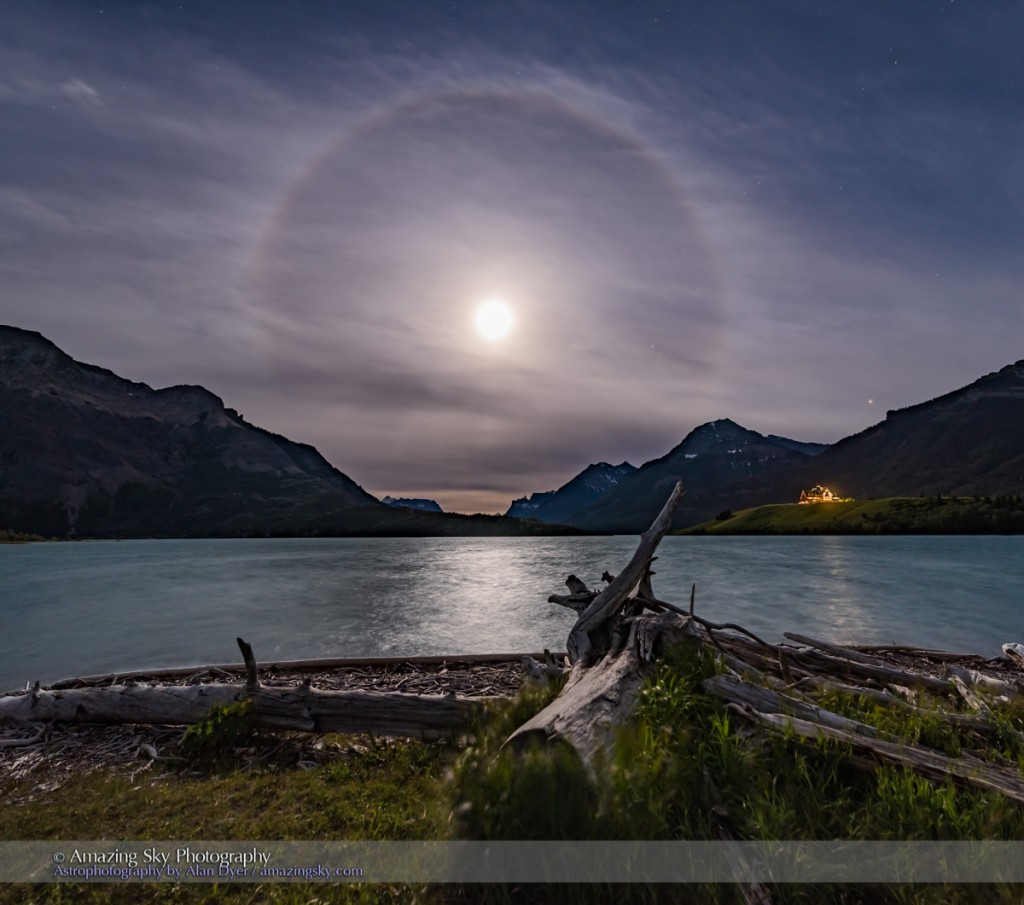 An ice crystal halo around the Full Moon on solstice eve, June 19, 2016, from Driftwood Beach at Waterton Lakes National Park, Alberta. Mars is the bright object at far right, Saturn is just right of the Moon. The iconic Prince of Wales Hotel is below Mars. This is a 3 panel vertical panorama, each panel with the 20mm Sigma lens at f/4 for 5 seconds at ISO 800. Stitched in ACR.