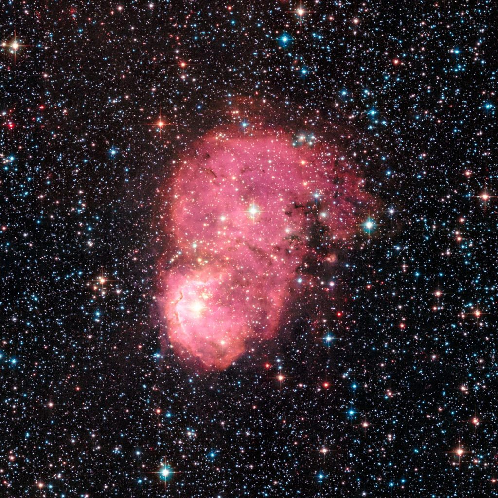 Una galaxia satélite de la Vía Láctea iluminada por una nebulosa de emisión