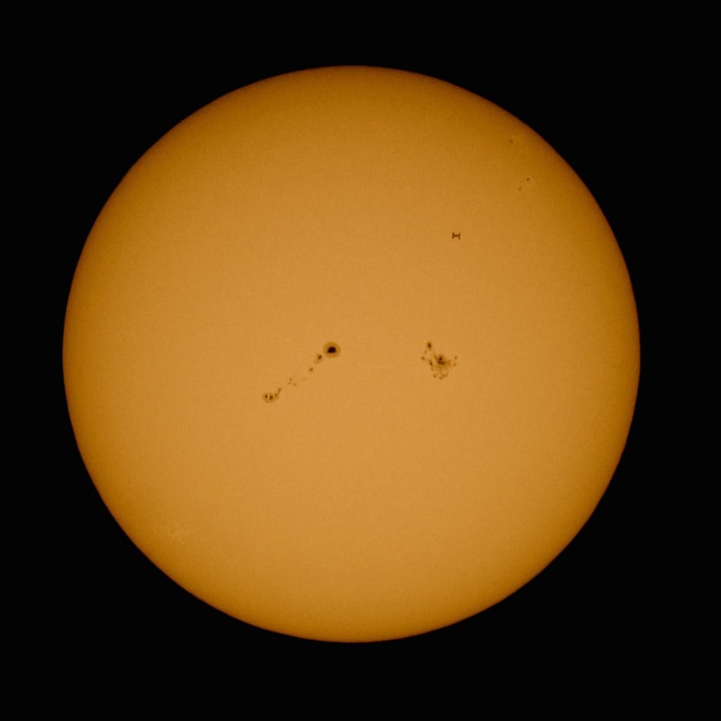 Imagen del tránsito de la ISS frente al Sol y las regiones 2673 y 2674