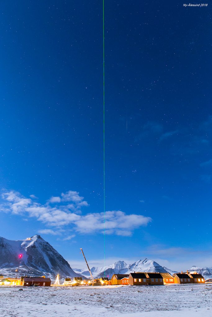 Foto de un meteoro y un rayo láser en Svalbard, Noruega