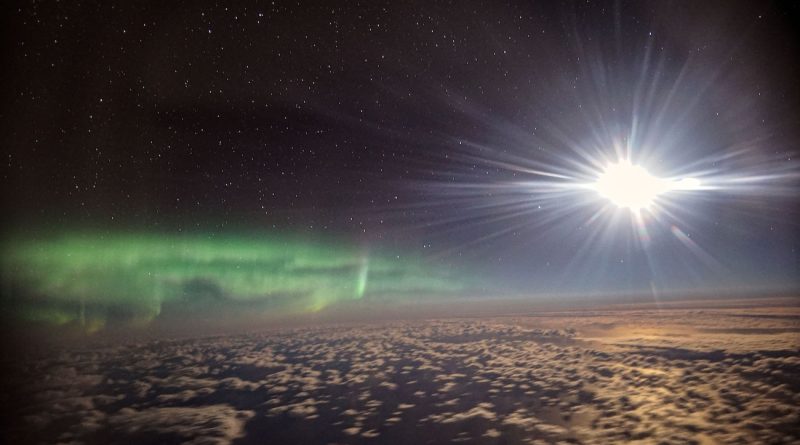 Auroras australes y la Luna captadas desde un avión sobre el Océano Pacífico