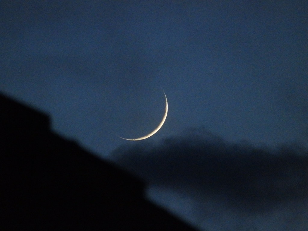 A slithering sliver of silver waxing crescent in the western sky