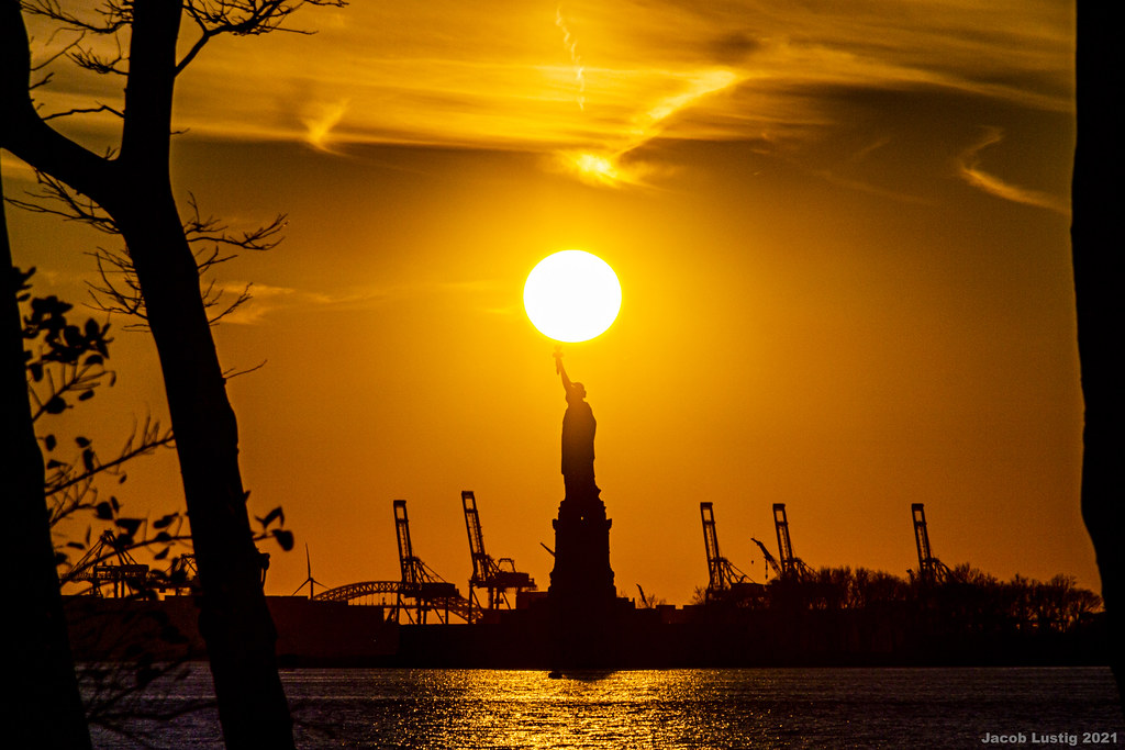 Foto del Sol y la Estatua de la Libertad tomada al atardecer